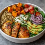 Healthy chicken sweet potato bowl with roasted sweet potatoes, grilled chicken, kale, and avocado.