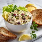 Easy high protein rotisserie chicken salad served in bowl with herbs and whole grain toast.