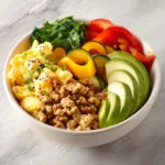Hearty turkey breakfast bowl with eggs vegetables and avocado.