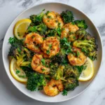 A healthy roasted shrimp and broccoli dinner served with lemon wedges and fresh parsley.