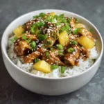 slow cooker pineapple chicken served over rice with pineapple sauce green onions and sesame seeds